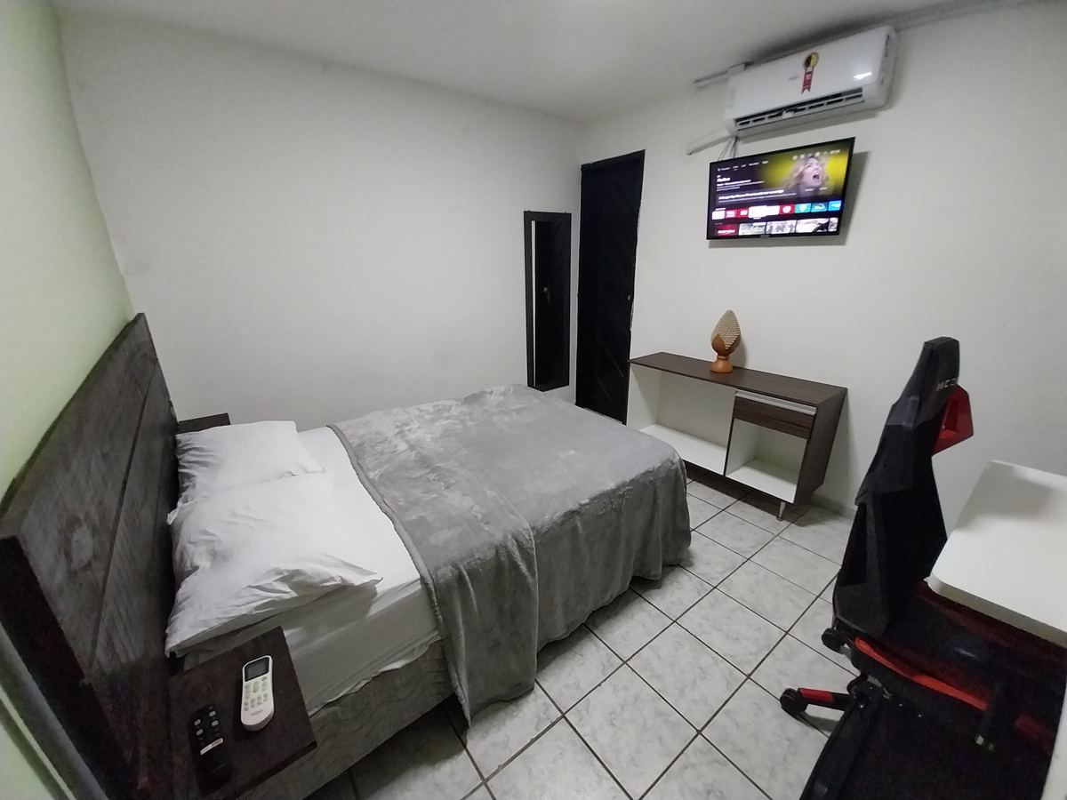 Quarto de casal com ar-condicionado, TV e mesa de trabalho